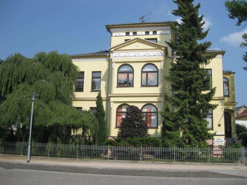 a yellow house with a tree in front of it at Holiday apartment in Waren Müritz in Waren