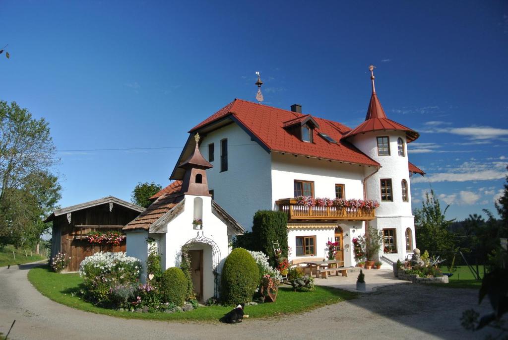 ein großes weißes Haus mit rotem Dach in der Unterkunft Holzleitnerhof in Traunstein