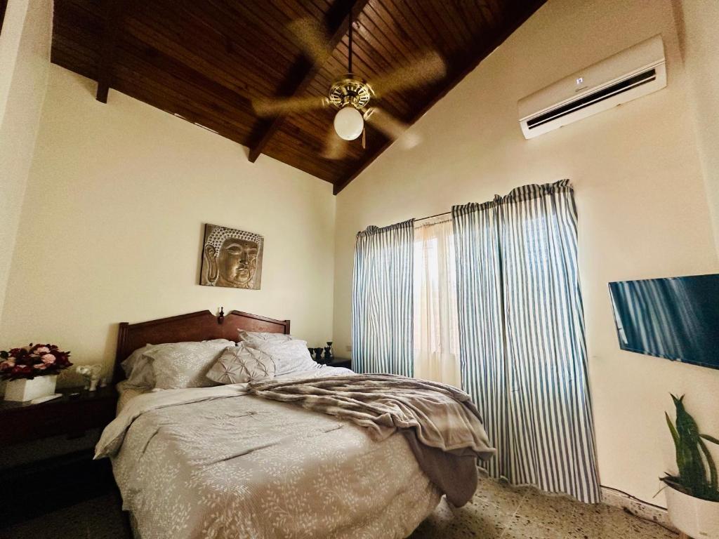 a bedroom with a bed and a ceiling fan at Villas del Mar in La Ceiba