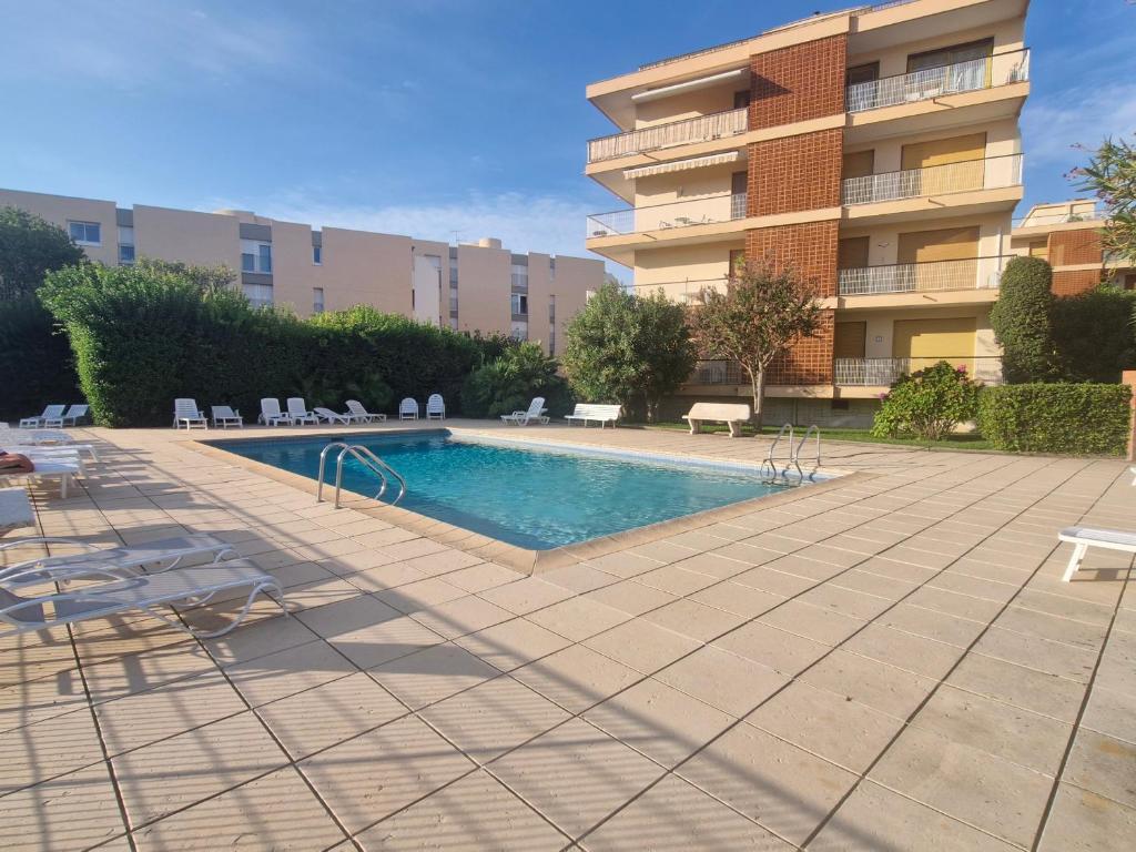 une piscine devant un immeuble dans l'établissement Beau 2 pièces climatisé avec terrasse et piscine, proche centre Sainte-Maxime - FR-1-780-85, à Sainte-Maxime