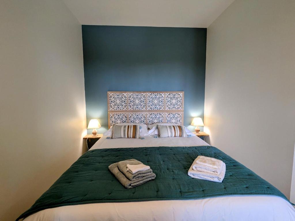 una camera da letto con un letto grande con due asciugamani sopra di Chambre cosy avec salle d'eau, accès piscine chauffée et Wi-Fi illimité - FR-1-591-620 a Faverolles