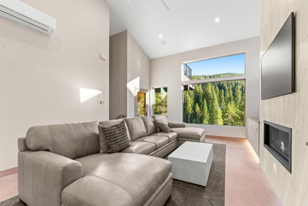 ein Wohnzimmer mit Couch und großem Fenster in der Unterkunft Inas Way Townhomes Unit C by Summit County Mountain Retreats in Keystone