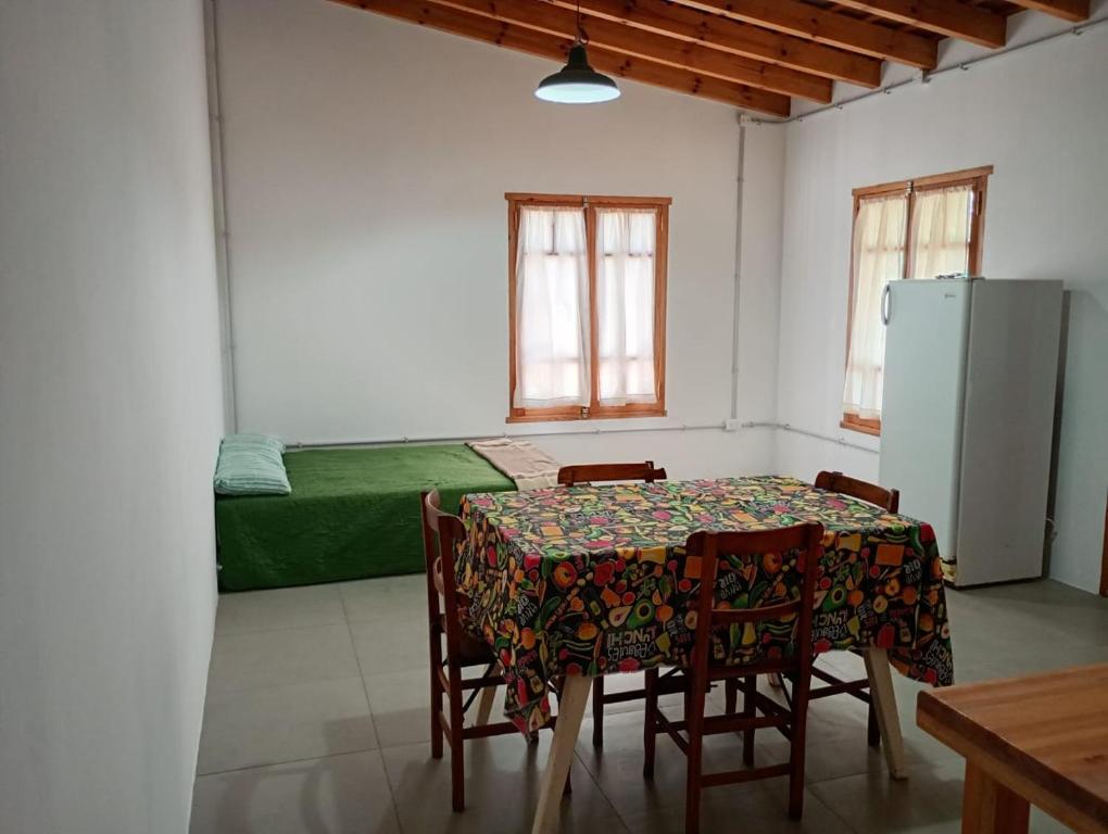 comedor con mesa, sillas y nevera en El nogalito quinta, en Lobos