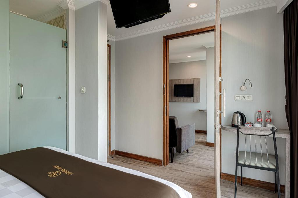Postel nebo postele na pokoji v ubytování Goldvitel Hotel Surabaya