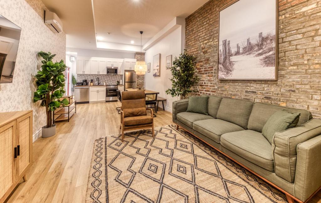 een woonkamer met een bank en een bakstenen muur bij North House - Bohemian Vieux Quebec Two Bedroom in Québec