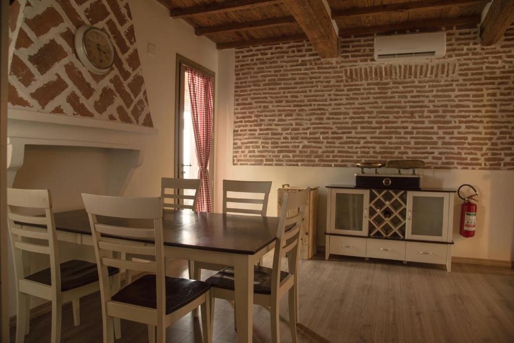 a dining room with a table and chairs and a stove at Agriturismo Ferrara Chalet in Vigarano Mainarda