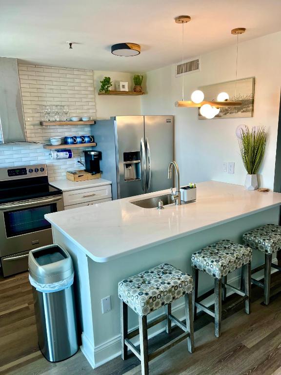 eine Küche mit einer großen Kücheninsel mit zwei Hockern in der Unterkunft Luxe by the Sea - 5-Star Beachfront Escape in Myrtle Beach