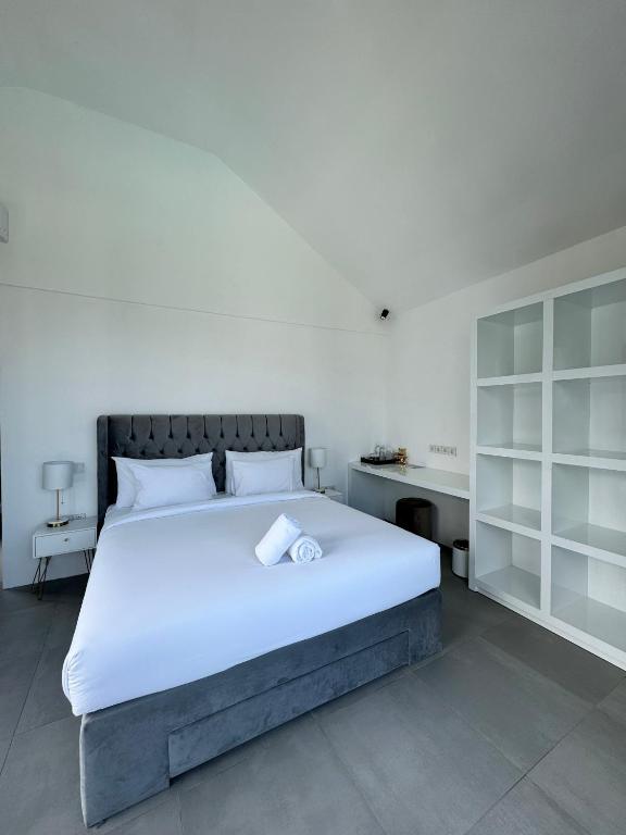 a bedroom with a large white bed and a desk at Villa Valeria in Ungasan