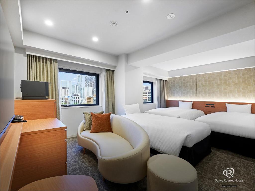 a hotel room with two beds and a tv at Daiwa Roynet Hotel Yokohama-Koen in Yokohama