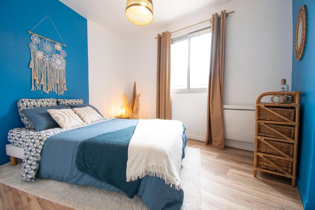 ein blaues Schlafzimmer mit einem Bett und einem Fenster in der Unterkunft Wood & Sea I Sauna & Hyper centre in Crozon