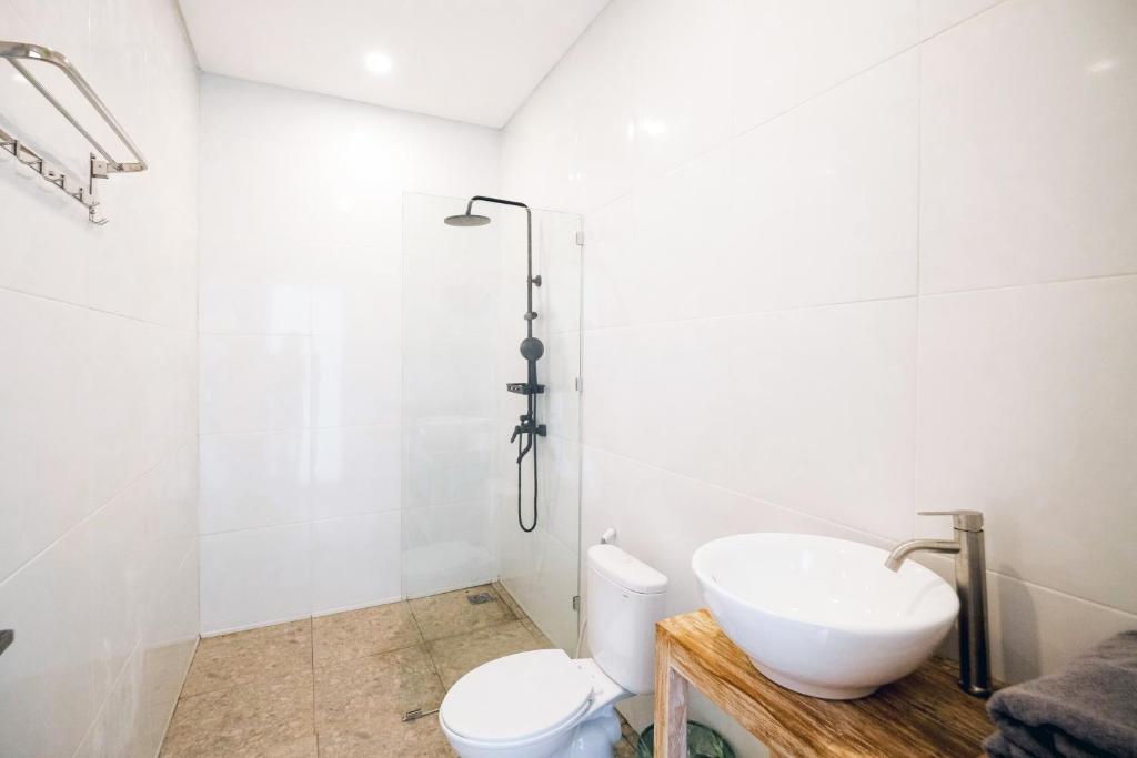 a white bathroom with a sink and a toilet at NEW Canggu Modern 3BR Villa with big Pool & Garden in Umalas