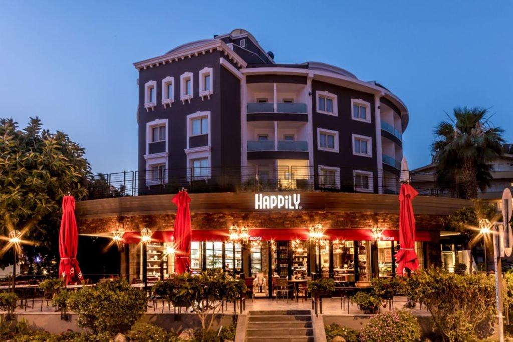 un hotel con sombrillas rojas frente a un edificio en Motto Premium Hotel&amp;Spa, en Marmaris