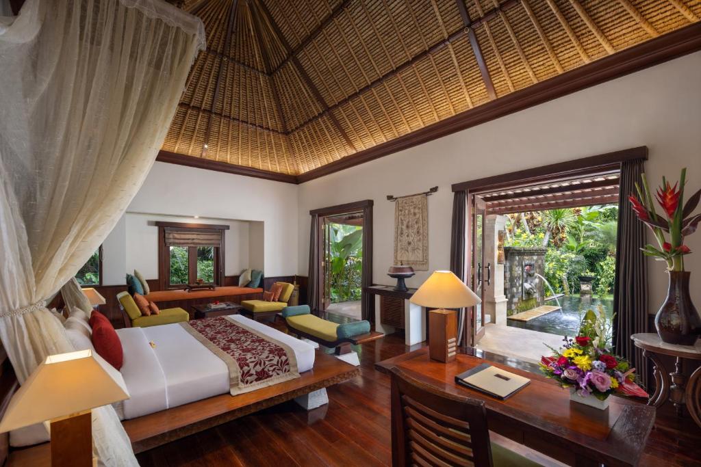 ein Schlafzimmer mit einem Bett und einem Schreibtisch in einem Zimmer in der Unterkunft Arma Museum & Resort in Ubud