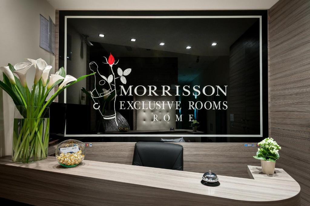 ein Spiegelbild eines Zeichens im Fenster eines Ladens in der Unterkunft Morrisson Exclusive Rooms in Rom