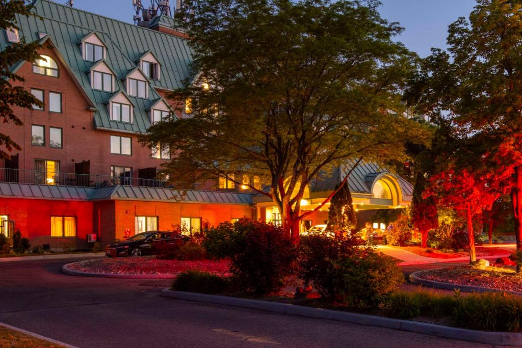 ガティノーにあるChateau Cartier Hotel & Resort Ascend Hotel Collectionの通りの前に木のある建物