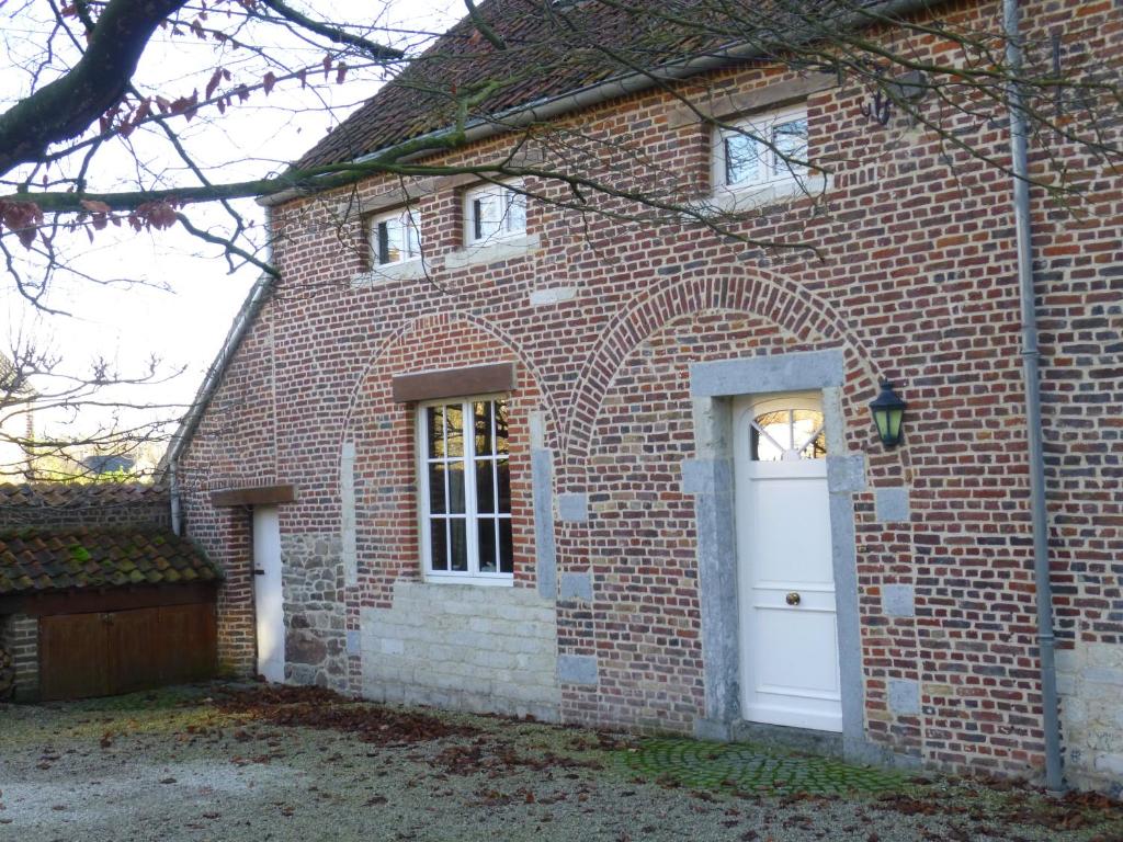 een stenen huis met een witte deur en ramen bij Maison Chantraine in Ramillies