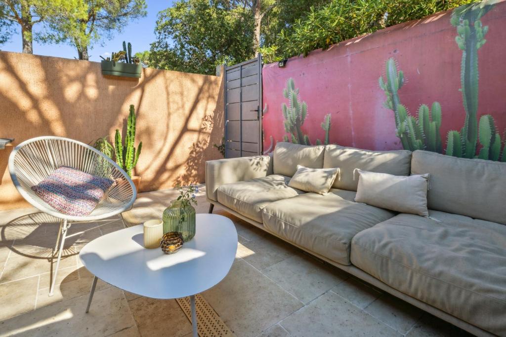 d'un canapé, d'une table et d'une chaise sur la terrasse. dans l'établissement Maison Font Mourrier - Maison piscine partagée, à Cogolin