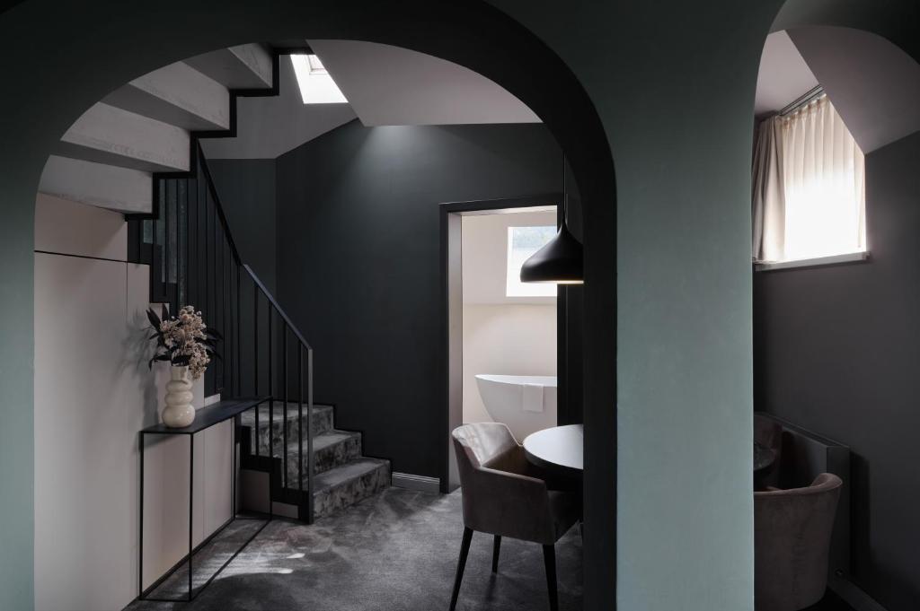 キッツビュールにあるERIKA Boutiquehotel Kitzbühelの階段、テーブル、椅子が備わる客室です。