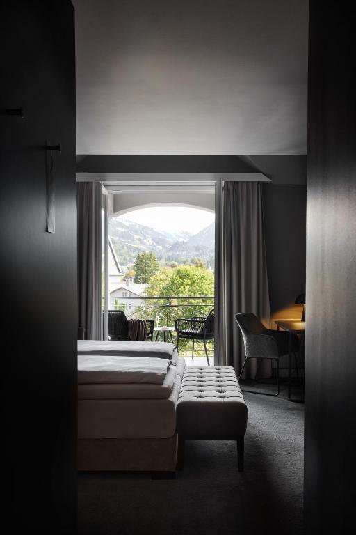 キッツビュールにあるERIKA Boutiquehotel Kitzbühelのベッドルーム1室(ベッド1台、大きな窓付)