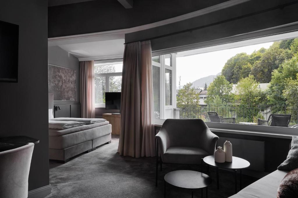 キッツビュールにあるERIKA Boutiquehotel Kitzbühelのソファと大きな窓のあるリビングルーム