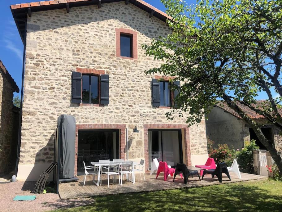 une maison avec des chaises et une table devant elle dans l'établissement Le gite dErin, à Saint-Yrieix-sous-Aixe