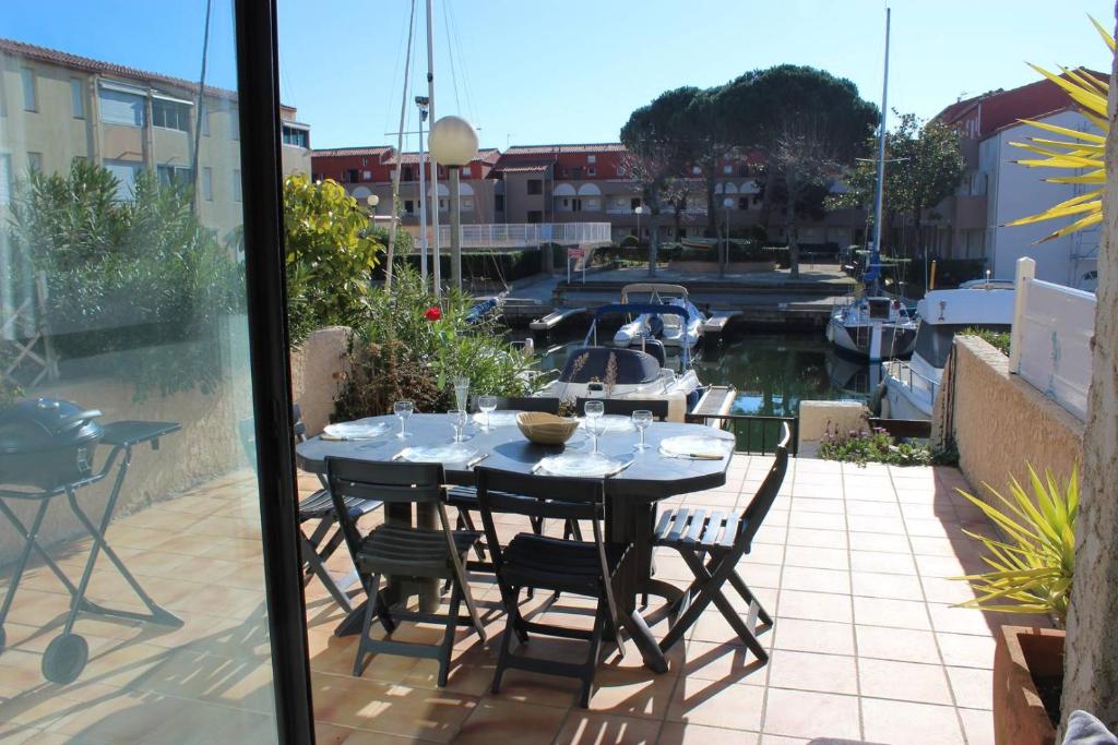 un balcon avec une table et des chaises et un port de plaisance dans l'établissement Face Lagune superbe appartement de plain pied avec parking - 6BAIE12, à Saint Cyprien Plage