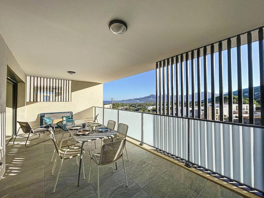 une salle à manger avec une table et des chaises sur un balcon dans l'établissement Appartement T3 dans une résidence neuve, à Calvi