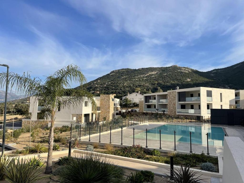 - une vue sur un bâtiment avec piscine dans l'établissement Magnifique T2 vue sur la baie de Calvi, à Calvi
