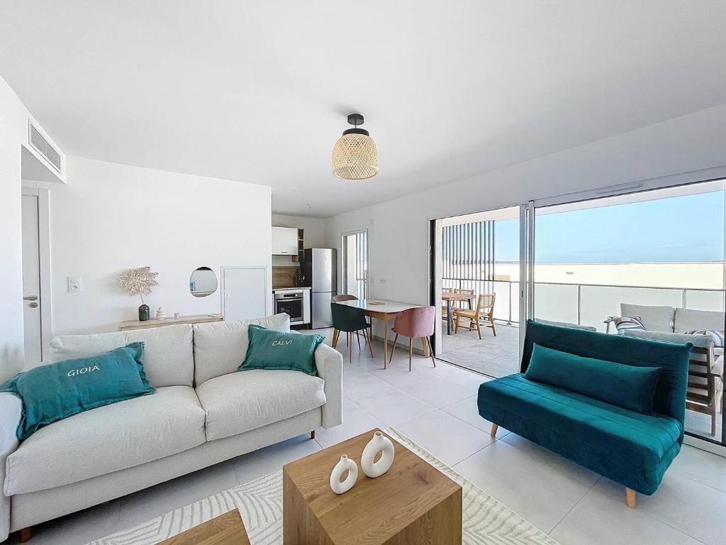 un salon avec un canapé et une table dans l'établissement Appartement dans résidence avec piscine, à Calvi