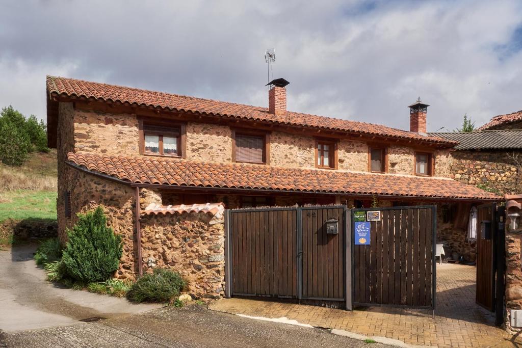 una casa de piedra con una puerta de madera delante de ella en Entre Valles, en Benllera