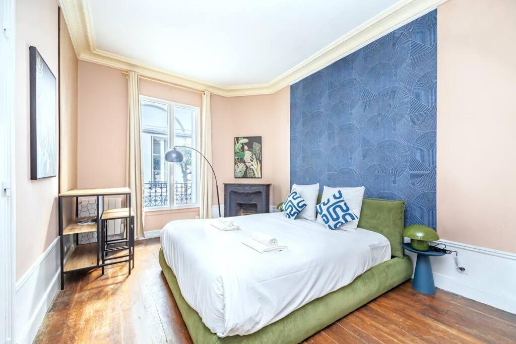 - une chambre dotée d'un lit avec un mur bleu dans l'établissement Studio confortable au centre Paris 14ème, à Paris