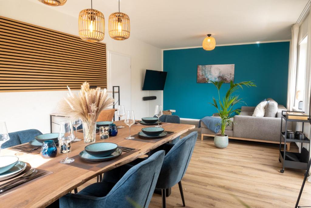 a dining room with a table and blue walls at Großes Apartment für 6 - Gasgrill Citynah Parken in Lippstadt