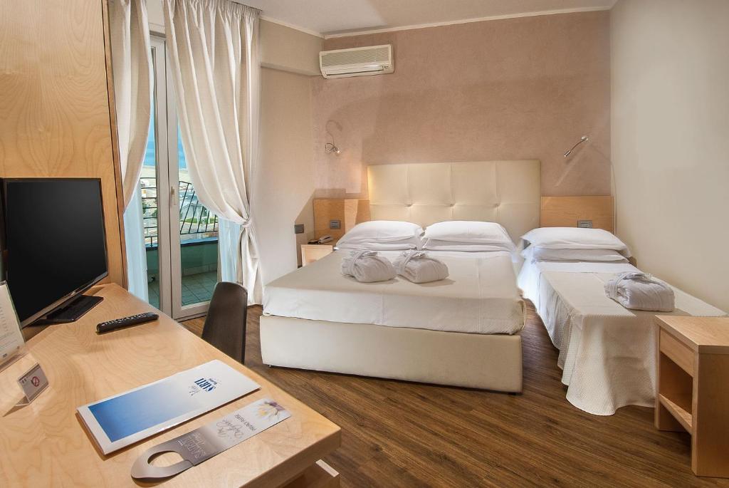 Postel nebo postele na pokoji v ubytování Hotel Sarti