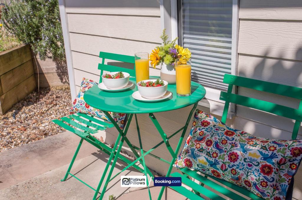 a table with two chairs and two cups of orange juice at Compact 1BR Studio, Fast Wi-Fi & Kitchenette, Great for Short Stays & Monthly Bookings in Little Marlow