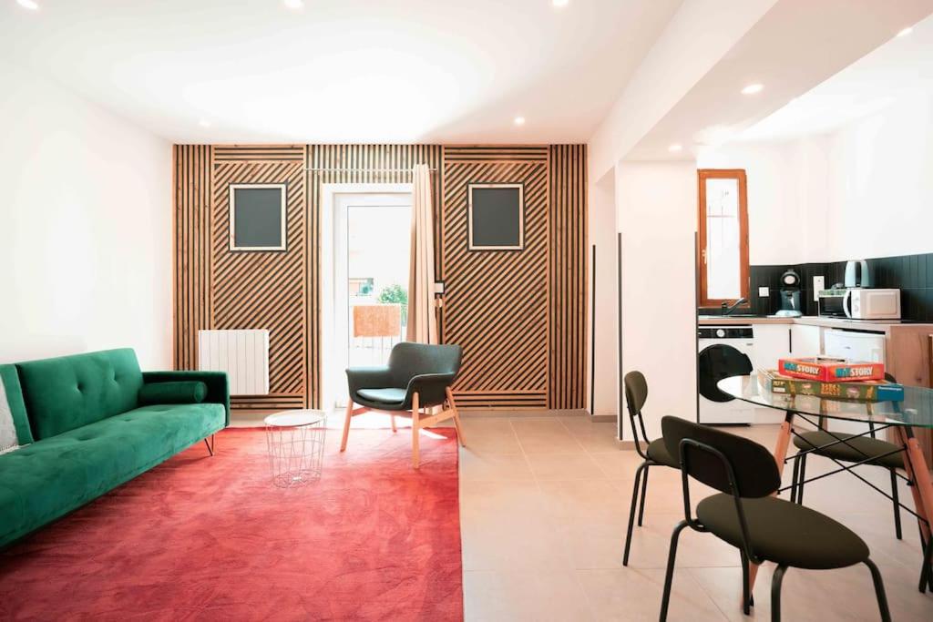 un salon avec un canapé vert et une cuisine dans l'établissement Appart 3 Grand 2 pièces en plein centre avec place de parking, à Aix-les-Bains