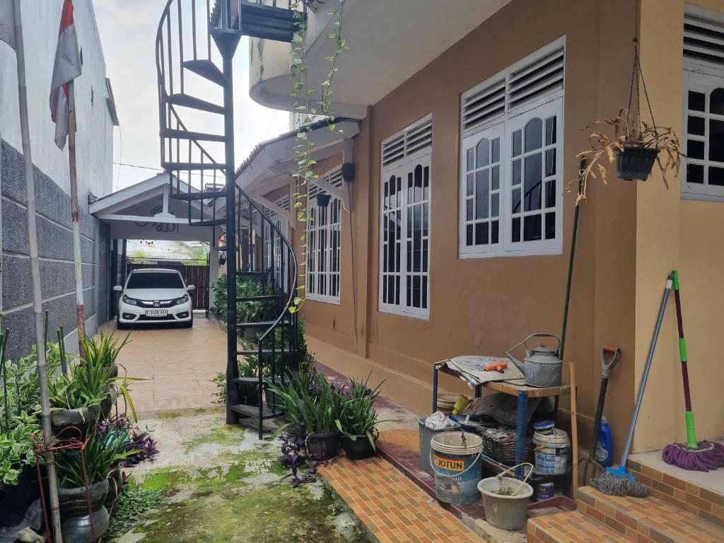 a house with a car parked in a driveway at Homes stay Lily in Semplak