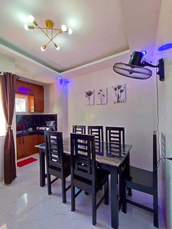 a dining room with a black table and chairs at Second Pad at Second floor in Bolinao
