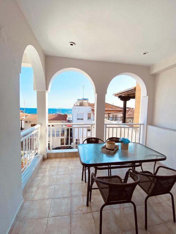a dining room with a table and chairs on a balcony at Vaso Apartment in Neos Marmaras