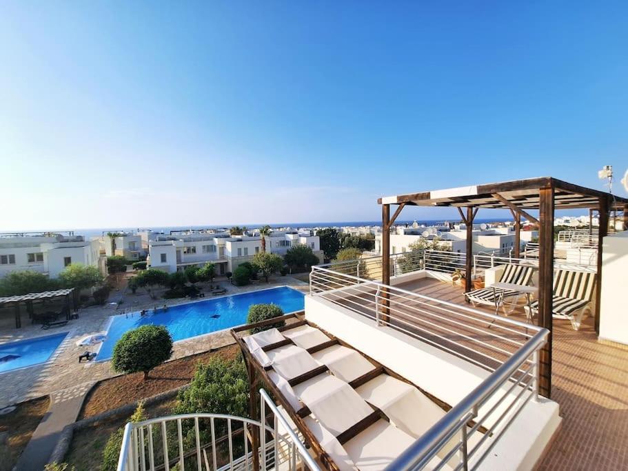 einen Balkon mit Poolblick in der Unterkunft Mountain Seaview Penthouse in a Holiday Village 10 in Ayios Yeoryios