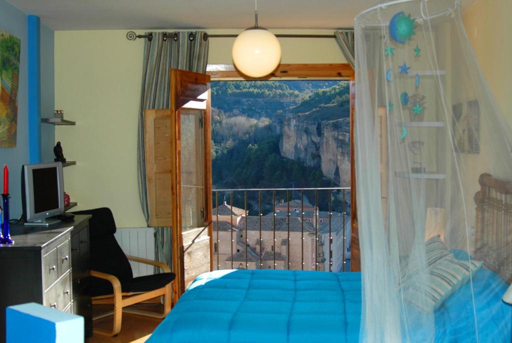 a bedroom with a bed and a window with a view at 2 Balcones a la Hoz in Cuenca