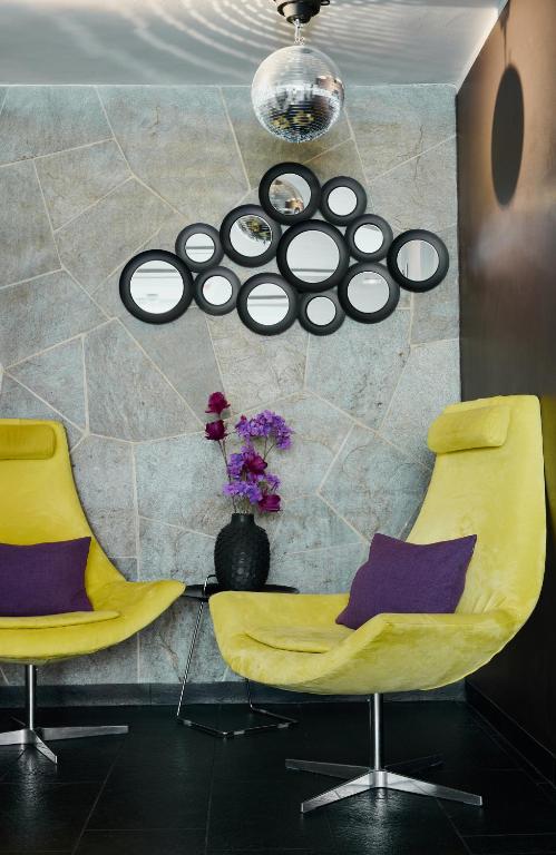 two yellow chairs and a table in a room at Leonardo Boutique Hotel Munich in Munich