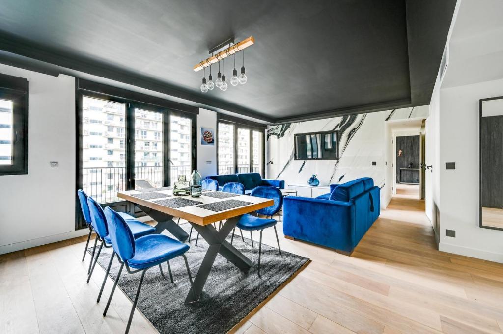 une salle à manger avec une table et des chaises bleues dans l'établissement Bluestay 55 - Charmant appartement à Paris, à Paris