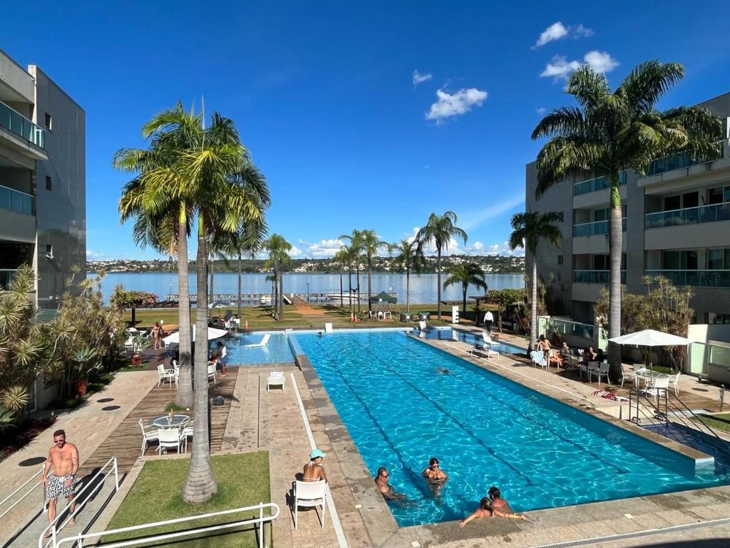 a pool at a resort with people in it at Flat na Beira do Lago in Brasilia