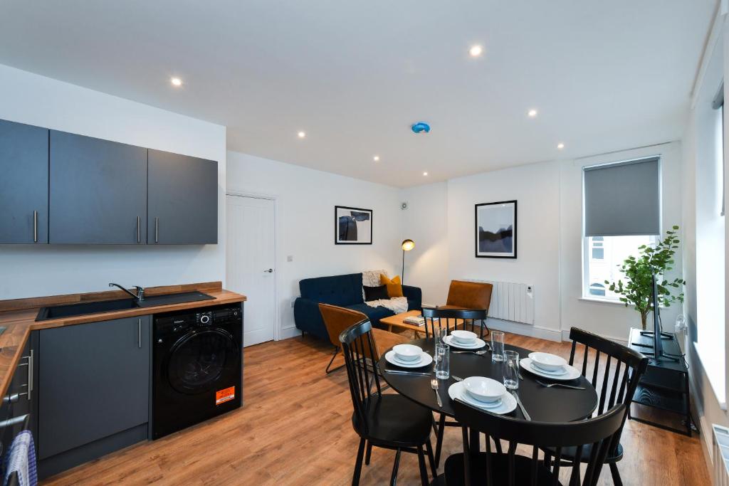 een keuken en woonkamer met een tafel en stoelen bij Charming 2Bed Flat - Spacious & Prime Location in Nottingham