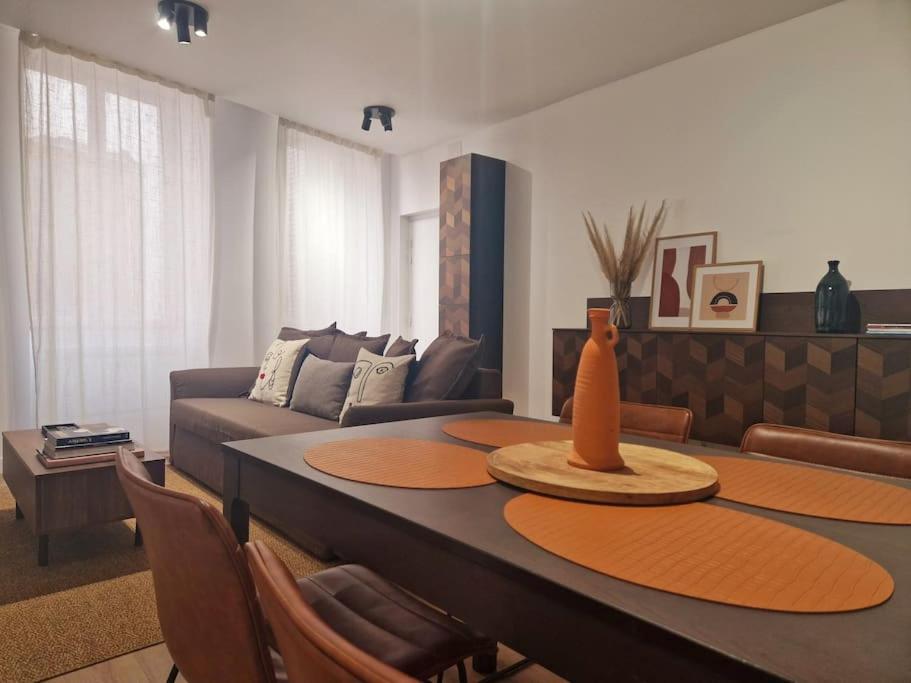 un salon avec une table et un canapé dans l'établissement La parenthèse T2 tout neuf moderne et chaleureux, à Chalon-sur-Saône