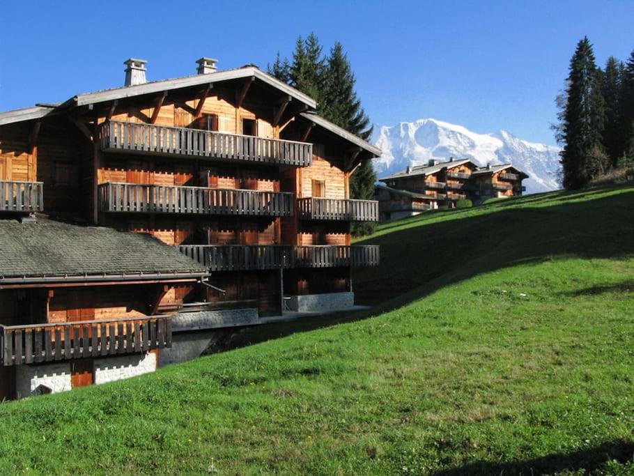 un grand bâtiment en bois avec balcon sur une colline dans l'établissement Vacances au sommet, idéal 5 à 6 personnes, à Saint-Gervais-les-Bains