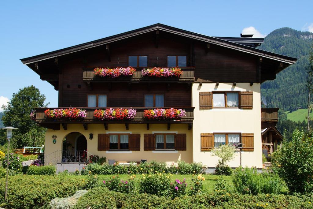 a house with flower boxes on the balcony at Ferienwohnungen Haus Mindermann in Lofer