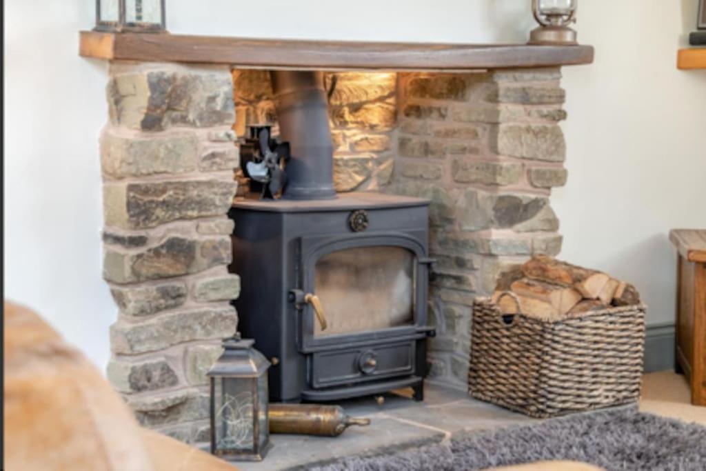 a stone fireplace with a stove in a room at Tranquil 4-bed Spectacular Views in Much Birch