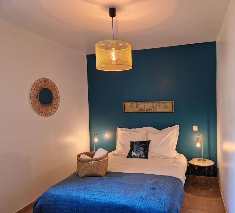 une chambre avec un lit avec un mur bleu dans l'établissement Mini villa 70 - piscine chauffée, à Serra-di-Ferro