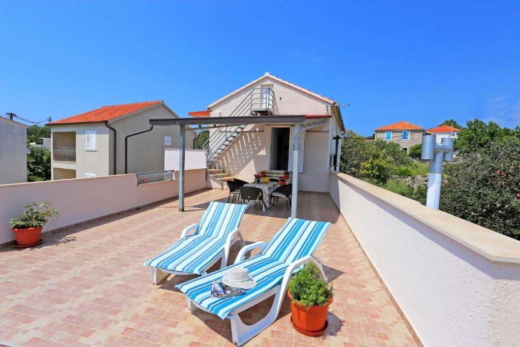 eine Terrasse mit 2 Stühlen und einem Tisch auf dem Dach in der Unterkunft Apartment Marija in Drvenik Mali